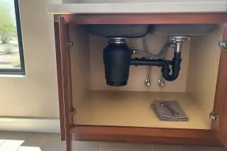 Cleaned garbage disposal and tools inside a kitchen cabinet in a Phoenix, AZ home.