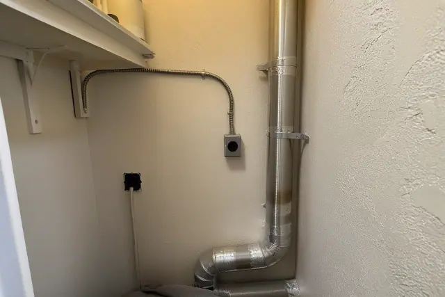 Metallic dryer exhaust venting with foil tape and clamps during a repair in a closet in Phoenix, AZ.