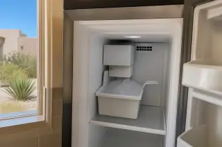 Reassembled ice maker and clean ice bin inside a residential freezer in a Phoenix, AZ home.