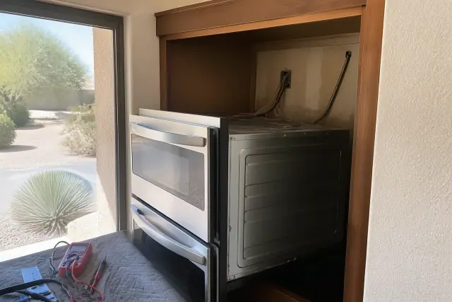 Double ovens partially installed in a kitchen cabinet with repair tools nearby in Phoenix, AZ.