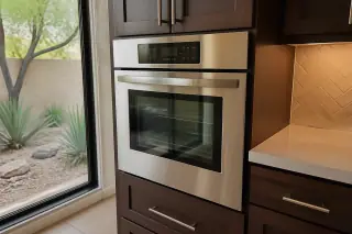 Built-in stainless steel wall oven installed flush in a Phoenix, AZ kitchen with xeriscape view.
