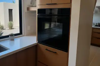 Cleanly installed built-in wall oven with desert landscape visible through the kitchen window in Phoenix, AZ.