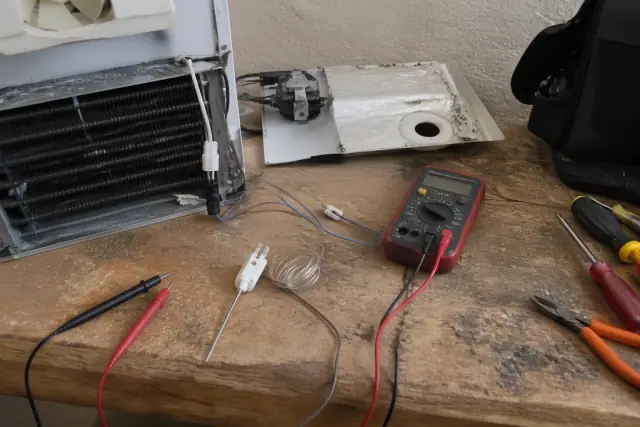 Refrigerator thermostat and electrical repair on a workbench in a workshop in Phoenix, AZ.