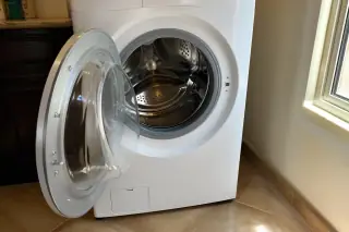 Rear venting system and drum belt of a stacked dryer unit in a laundry room in Phoenix, AZ.