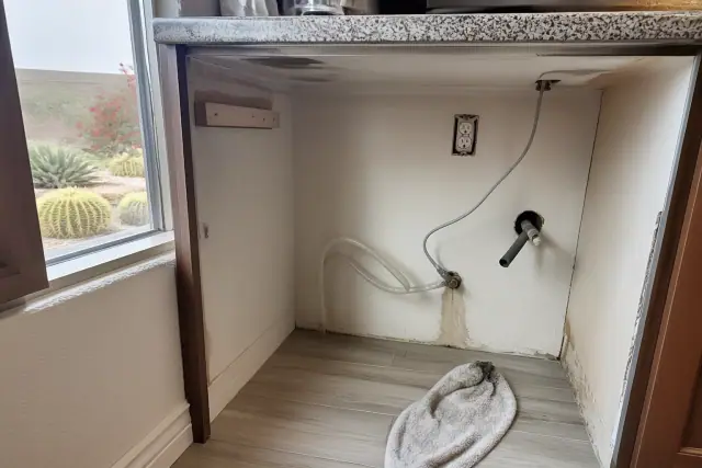 Dishwasher plumbing and electrical connections in a kitchen repair space in Phoenix, AZ.