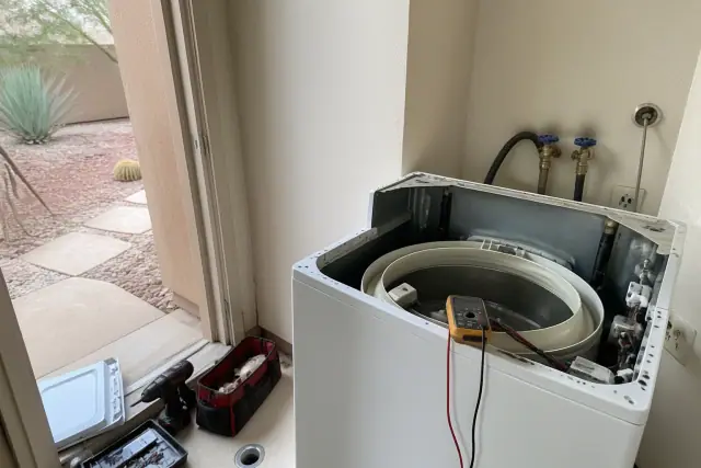 Whirlpool washer repair in a utility room with tools visible in Phoenix, AZ.