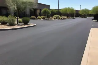 Freshly paved asphalt parking spaces in Phoenix, AZ, under bright midday sunlight.
