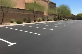 Freshly paved parking stalls with white striping and desert landscaping in Phoenix, AZ.