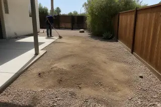 Worker sweeping debris after saguaro cactus removal next to a concrete patio in Phoenix, AZ.