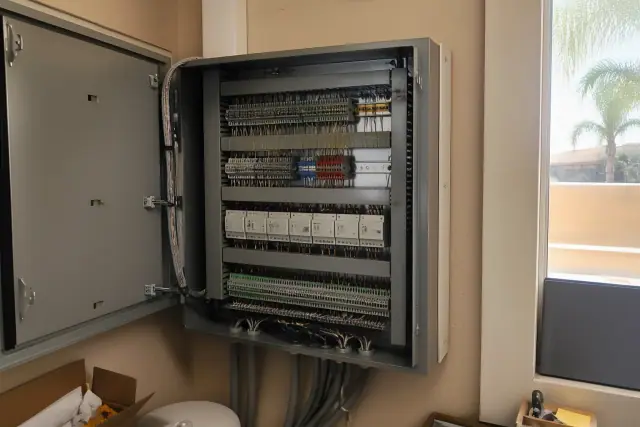 Building automation control cabinet with neat wiring installed on a tan stucco wall in Avondale, AZ.