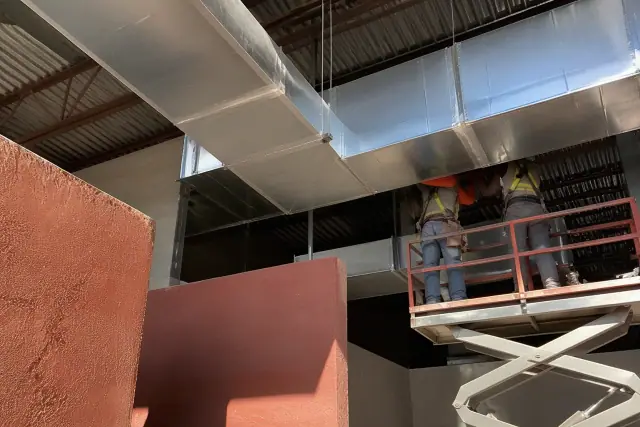 Sheet metal workers installing galvanized steel rectangular ductwork in a commercial building in Scottsdale, AZ.