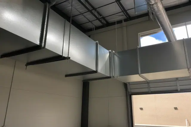 Galvanized steel ductwork installation suspended from an industrial ceiling in Surprise, AZ.