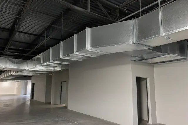 Galvanized steel ductwork installation suspended from an industrial ceiling in Phoenix, AZ.