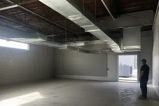 Galvanized steel ductwork suspended from an industrial warehouse ceiling in Phoenix, AZ.