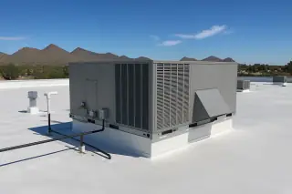 Reflective coated rooftop with a secured HVAC unit and desert mountain backdrop in Phoenix, AZ.
