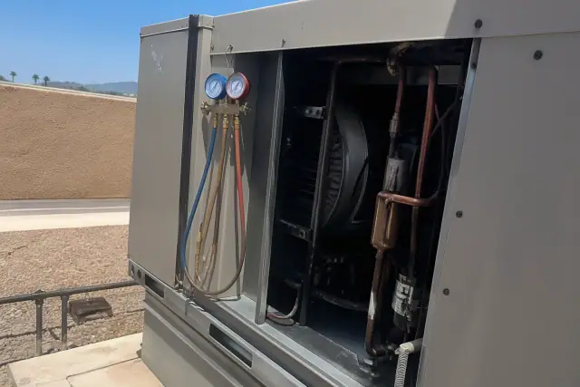 Technician performing a seasonal commercial HVAC tune-up on a rooftop unit in Peoria, AZ.
