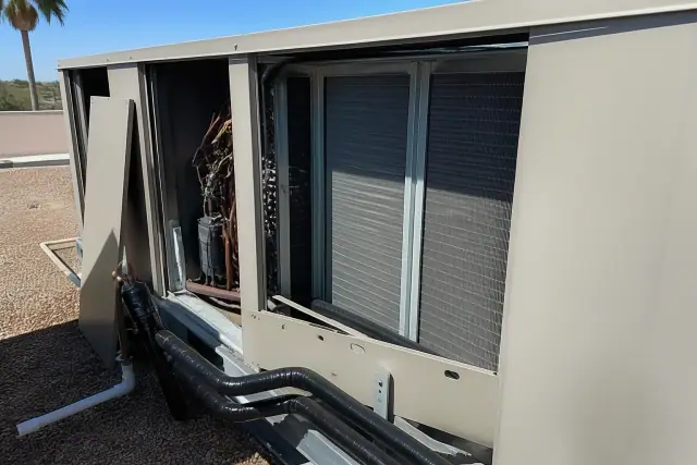 Rooftop commercial HVAC unit with copper lines and an open panel on a gravel roof in Phoenix, AZ.