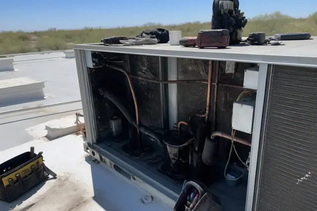 HVAC technician performing a seasonal rooftop unit tune-up in Goodyear, AZ.