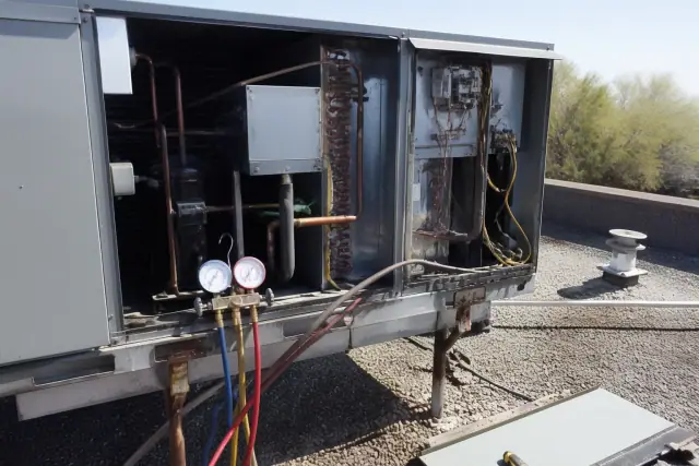 HVAC technician performing a seasonal tune-up on a commercial rooftop unit in Mesa, AZ.