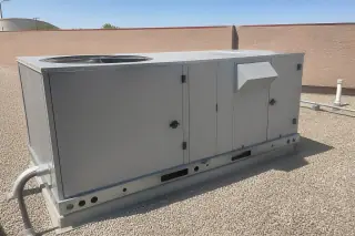 Completed commercial HVAC unit on a gravel roof with a stucco wall in Phoenix, AZ.
