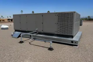 Wide view of a finished commercial HVAC rooftop unit on a gravel roof in Phoenix, AZ.