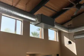 Commercial air purification unit installed in supply ductwork with desert light in a Phoenix, AZ warehouse.