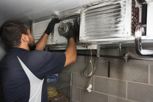 Technician repairing a walk-in cooler evaporator coil at a commercial job site in Avondale, AZ.
