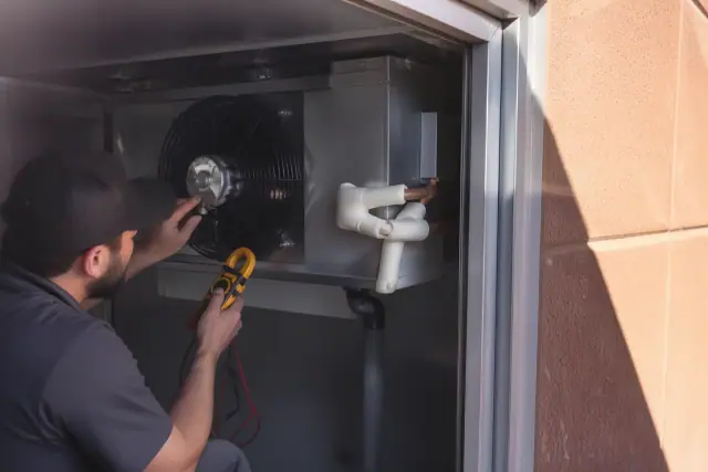 Mechanic testing a walk-in cooler evaporator fan motor during a repair in Scottsdale, AZ.