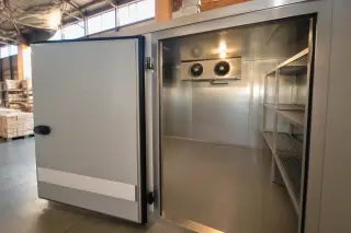 Stainless steel evaporator coil installed inside a walk-in commercial refrigerator in a Phoenix, AZ warehouse.