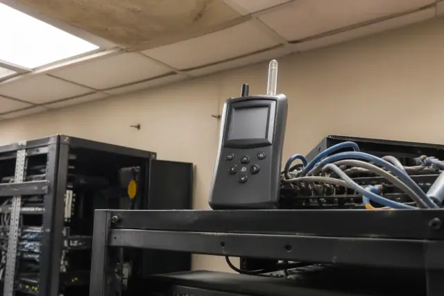 Portable air quality monitor on a server rack shelf inside a Phoenix, AZ server room.