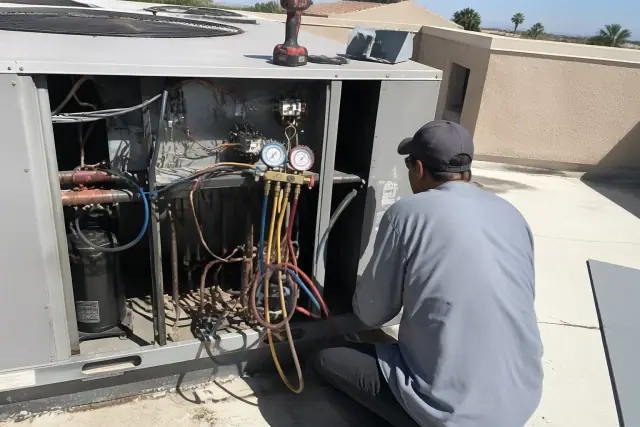 Technician performing a seasonal tune-up on a commercial rooftop unit in Phoenix, AZ.
