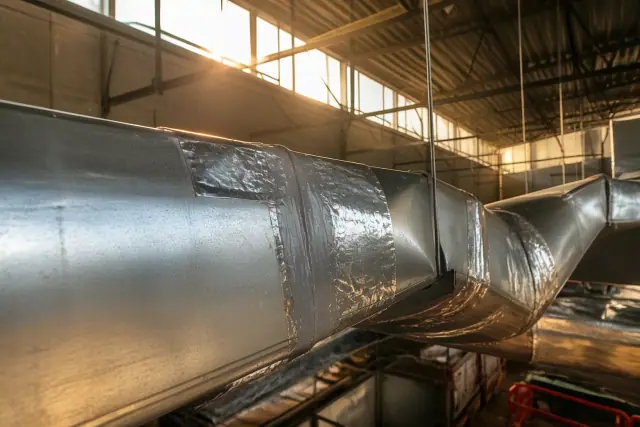 Silver mastic sealant and aluminum tape applied to galvanized steel ductwork at an industrial site in Phoenix, AZ.