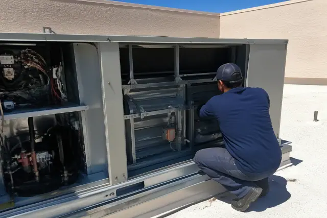 Technician performing a seasonal tune-up on a commercial rooftop unit in Phoenix, AZ.