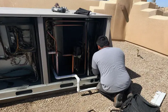 Technician performing a seasonal tune-up on a gas-electric rooftop unit in Phoenix, AZ.