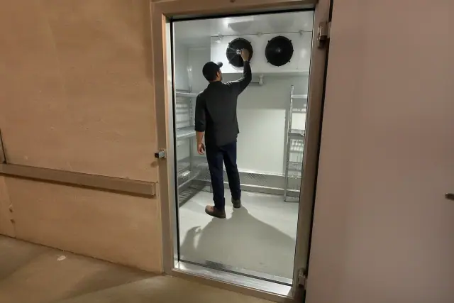 Interior of a walk-in commercial refrigeration unit with an evaporator coil in a Phoenix, AZ facility.