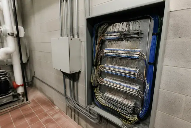 Wall-mounted HVAC control enclosure with bundled wiring in a mechanical room in Phoenix, AZ.