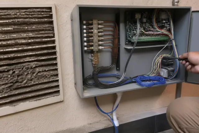Pneumatic-to-DDC controls retrofit inside an open HVAC panel with wiring and copper lines at a commercial site in Phoenix