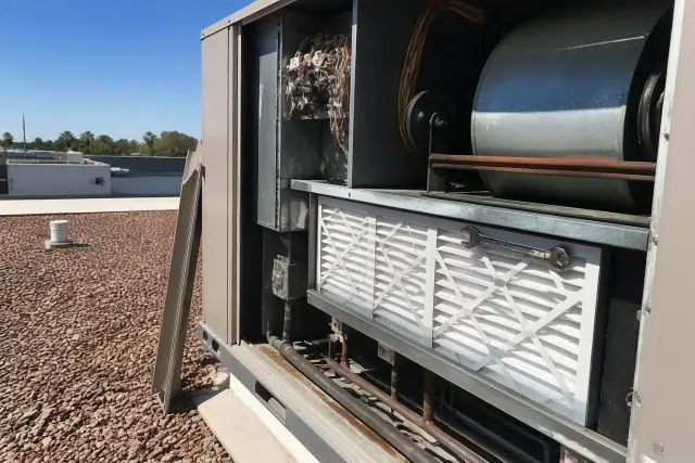 Technician performing a seasonal maintenance tune-up on a rooftop HVAC unit in Phoenix, AZ.