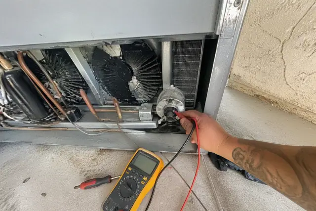 Contractor repairing an evaporator coil in a reach-in cooler at a jobsite in Phoenix, AZ.