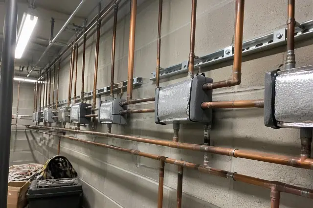 Refrigerant piping and insulated branch selector boxes installed in a mechanical room in Phoenix, AZ.