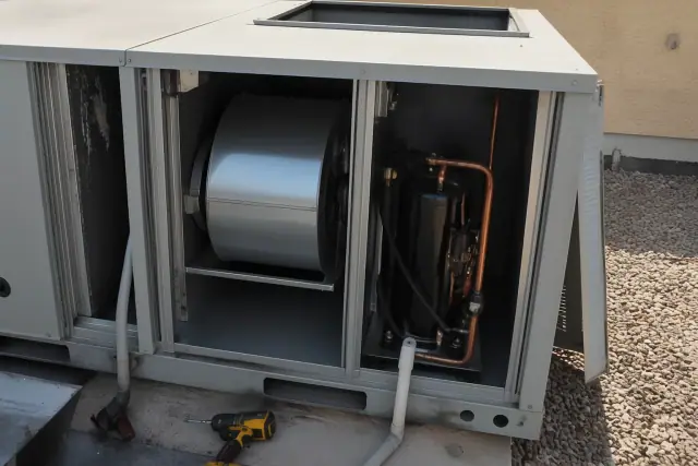 HVAC technician performing a seasonal tune-up on a commercial rooftop unit in Gilbert, AZ.