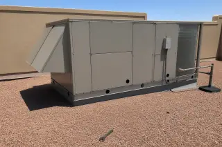 Cleaned commercial HVAC rooftop unit with an idle wrench on a gravel roof in Phoenix, AZ.