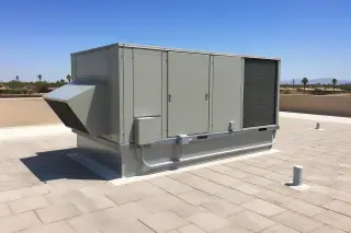 Closed commercial HVAC unit on a sun-bleached concrete paver roof in Phoenix, AZ.