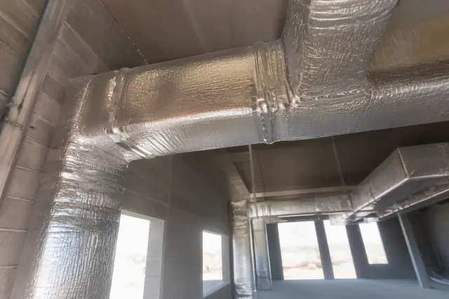 Sealed and insulated metal ductwork with reflective thermal wrap and foil tape at a job site in Phoenix, AZ.