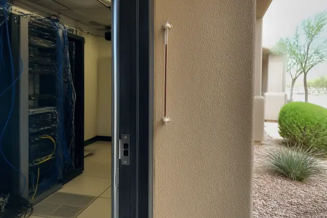 Glass-tube wall thermometer mounted beside a server room doorway in Phoenix, AZ.