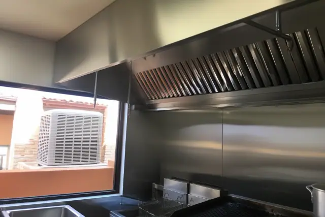 Type I grease hood system with stainless steel baffles and ventilation duct in a Phoenix, AZ commercial kitchen.