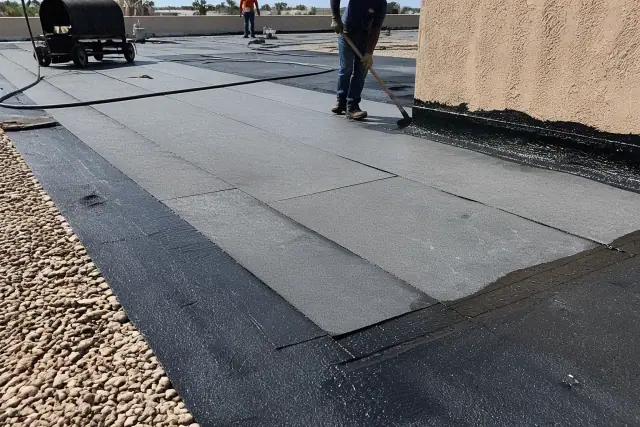 Built-up roofing installation with bitumen layers on a commercial building rooftop in Phoenix, AZ.