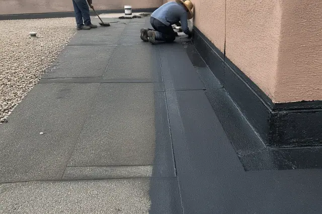 Built-up roofing with overlapping bitumen layers and a fresh asphalt lap seam on a gravel roof in Phoenix, AZ.