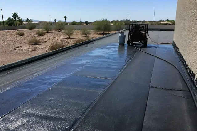 Layers of bitumen-saturated felt being fused on a commercial roof deck during a project in Surprise, AZ.