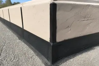 Sealed vertical joints and corner flashing on a built-up roof with a sun-bleached stucco parapet in Phoenix, AZ.